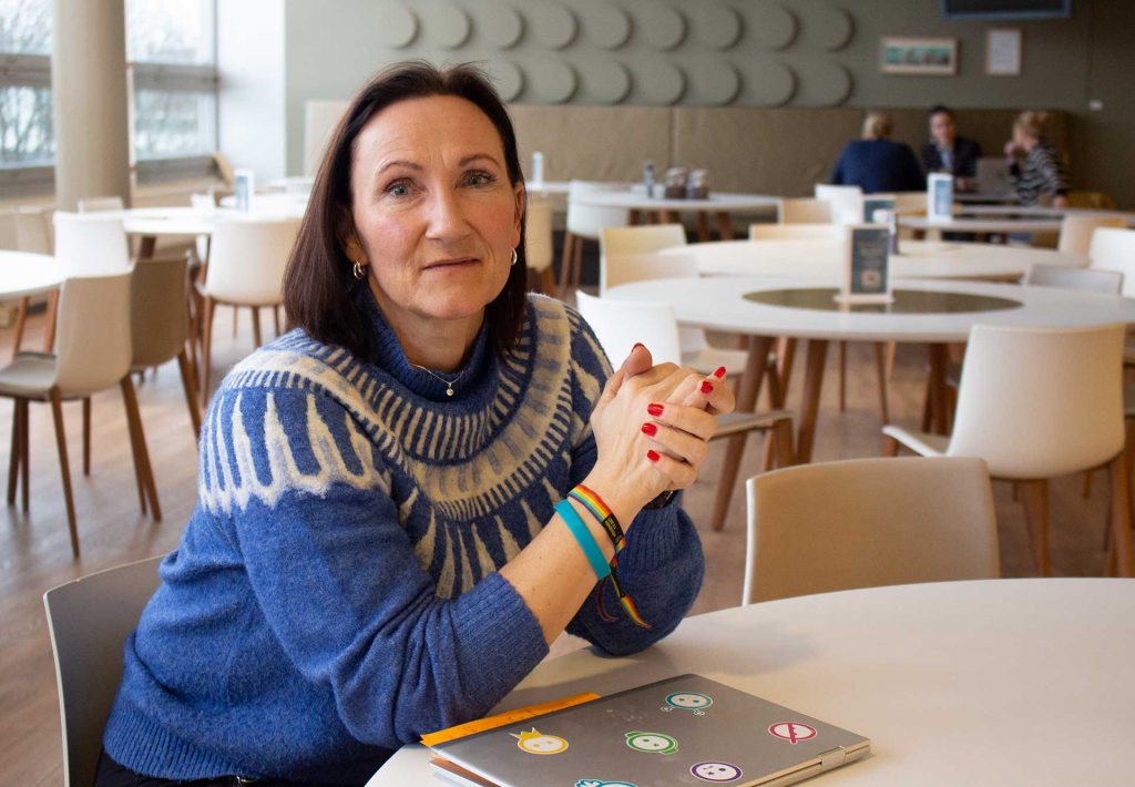 Siri Antonsen i NRKs kantine, med pc-en foran seg, mens hun ser inn i kameraet