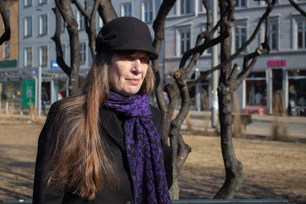 Berit Vegheim er leder i Stopp Diskrimineringen, hun står utenfor i byen foran et tre av tykke grener