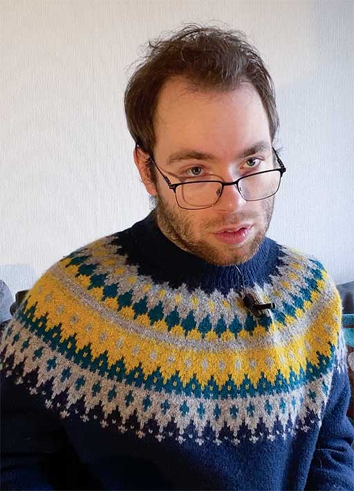 Johannes Loftsgård ser i kameraet i sin genser som er mønstret